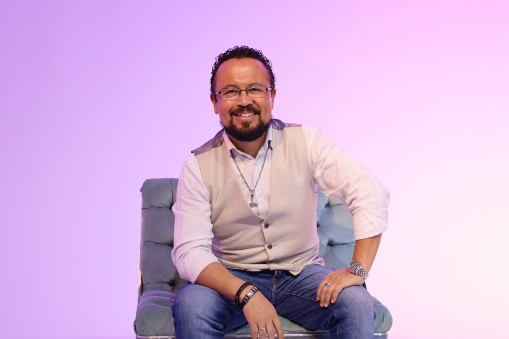 Óscar Avendaño, experto en LinkedIn en Colombia y copresentador de TecnoMarketing Podcast Óscar Avendaño, experto en LinkedIn en Colombia, sonriendo sentado en un sillón sobre fondo violeta